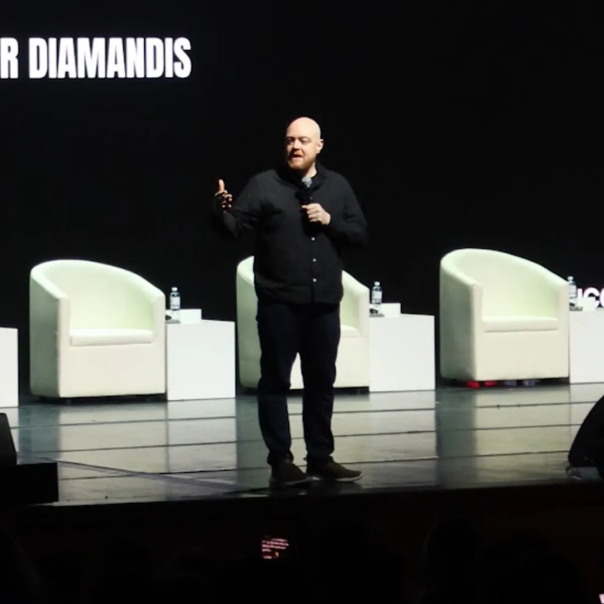 Dan Fitzpatrick speaking on stage at an event with Peter Diamandis